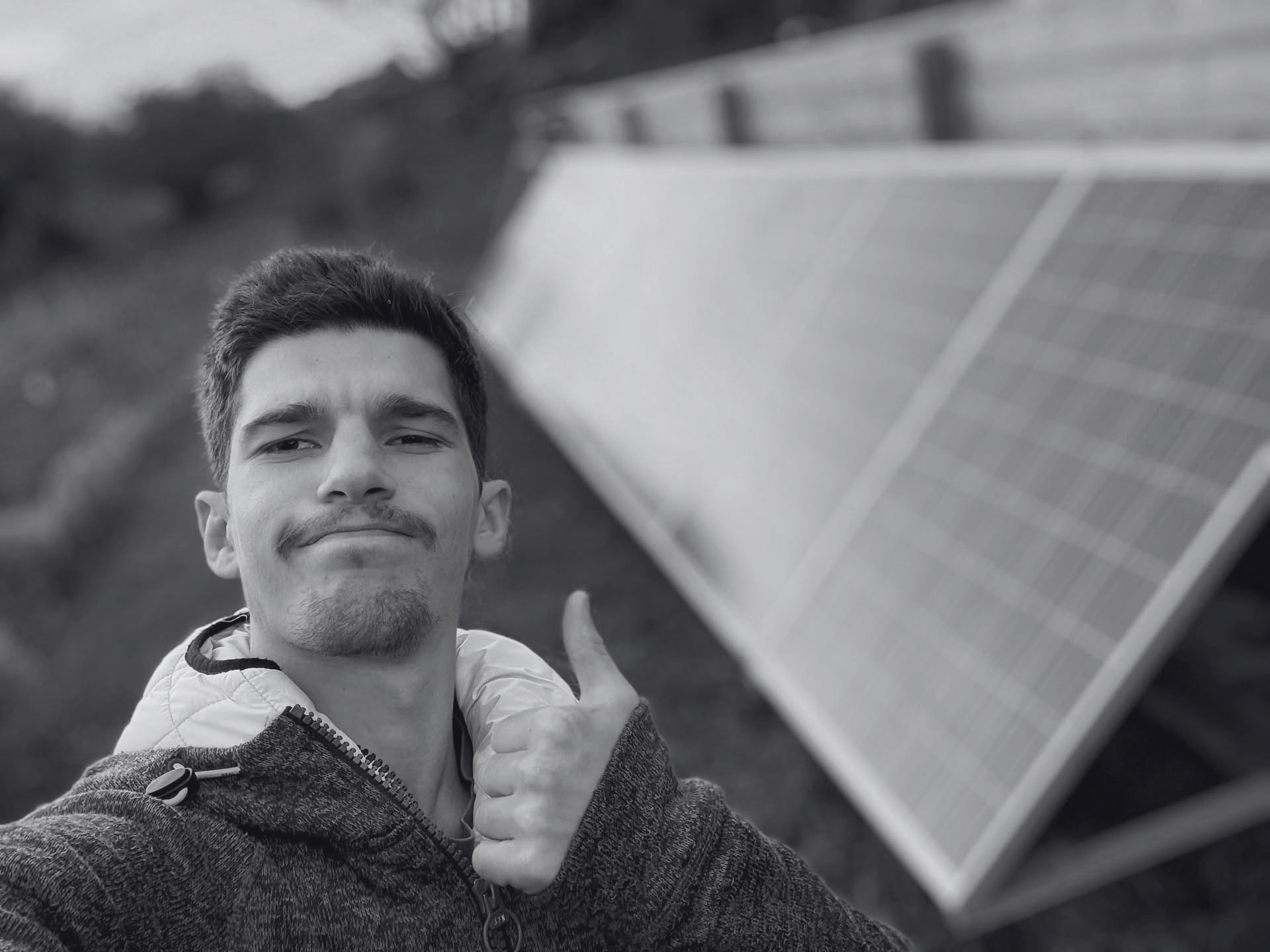 Alexandre, électricien Ohmelec, devant un panneau photovoltaïque